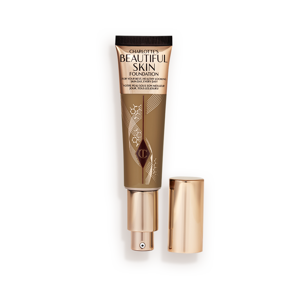 Beautiful Skin Foundation in 12N open An open foundation wand in gold packaging with a pump dispenser and a dark-brown-coloured body to show the shade of the foundation inside.