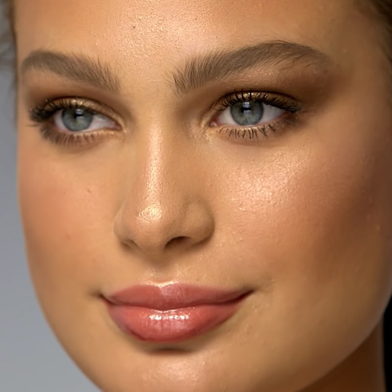 A medium-tone model with blue eyes wearing dark brown eyeliner in a smokey-smudged style. 