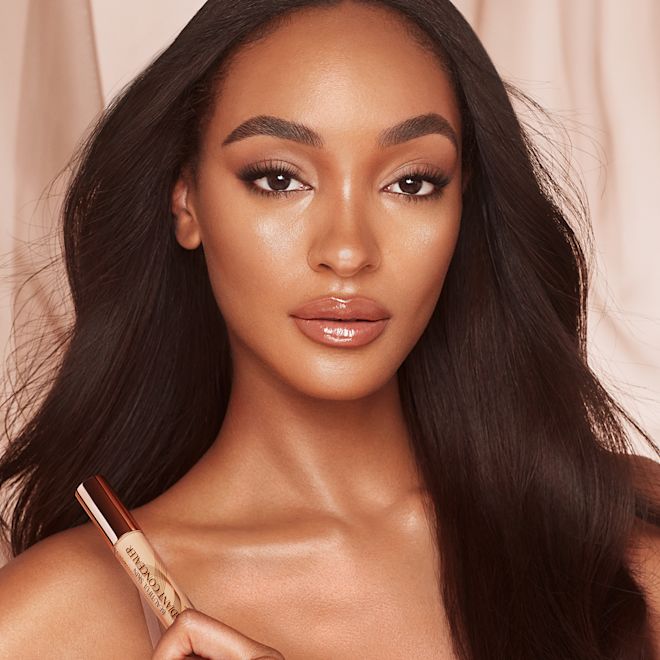Beautiful Skin concealer on deep-tone model Deep-tone model with brown eyes wearing a radiant, concealer that brightens, covers blemishes, and makes her skin look fresh along with nude lip gloss and subtle eye makeup.