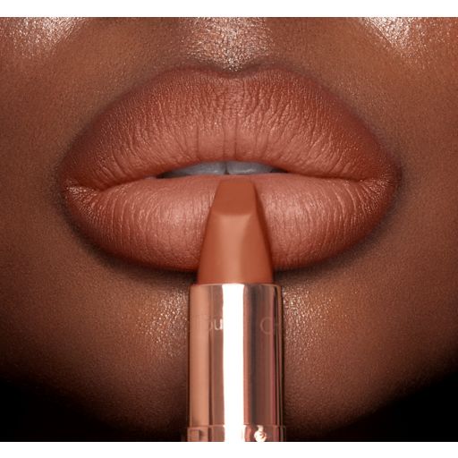 Matte Revolution The Super Nudes in Catwalking on deep-tone lips close-up Lips close-up of a deep-tone model wearing a fresh, neutral nude peach lipstick with a matte finish.