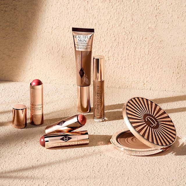 Cream products still life Charlotte's Beautiful Skin collection and Beach Sticks cream blush sticks on a beachy backdrop