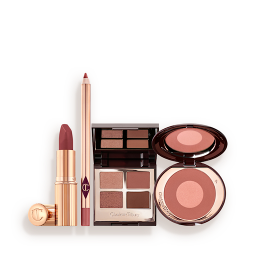 Pillow Talk Makeup Secrets Makeup Kit A makeup kit containing a two-tone pink and rose gold blush, a berry and pink quad eyeshadow palette, a nude-pink lip liner pencil, and rose-pink lipstick.