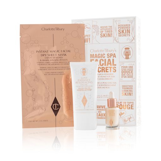 Magic Spa Facial Secrets displayed with packaging An elegant, white and gold skincare box with text in shiny gold colour that reads, 'Charlotte Tilbury's Magic Spa Facial Secrets' along with an exfoliating, wash-off mask in a white-coloured tube with a travel-size bottle of luminous face serum with a dropper lid, and a face mask in rose-gold-coloured foil packaging.