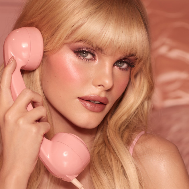 A fair skin blonde model wearing a pink makeup look