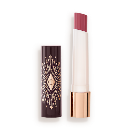 Hyaluronic Happikiss in Enchanting Kiss lid removed An open lipstick lip balm in a peachy nude rose shade, in white and gold tube with a black-coloured lid with gold sparkles all over it.