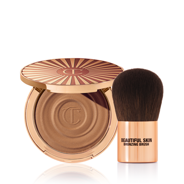 Beautiful Skin Sun-Kissed Radiant Bronzer and Brush An open cream bronzer compact with gold-coloured packaging with a bronzer brush with soft,d ark-brown-coloured bristles and a golden-coloured handle.