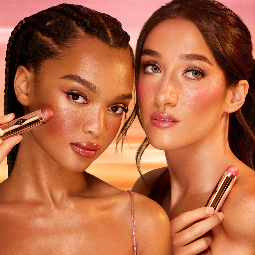 Two models wearing evening makeup looks using Charlotte Tilbury Beach Sticks