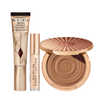 Foundation in a sleek gold-coloured tube with a concealer in a glass tube and gold-coloured lid, and dark brown cream bronzer compact in gold-coloured packaging.