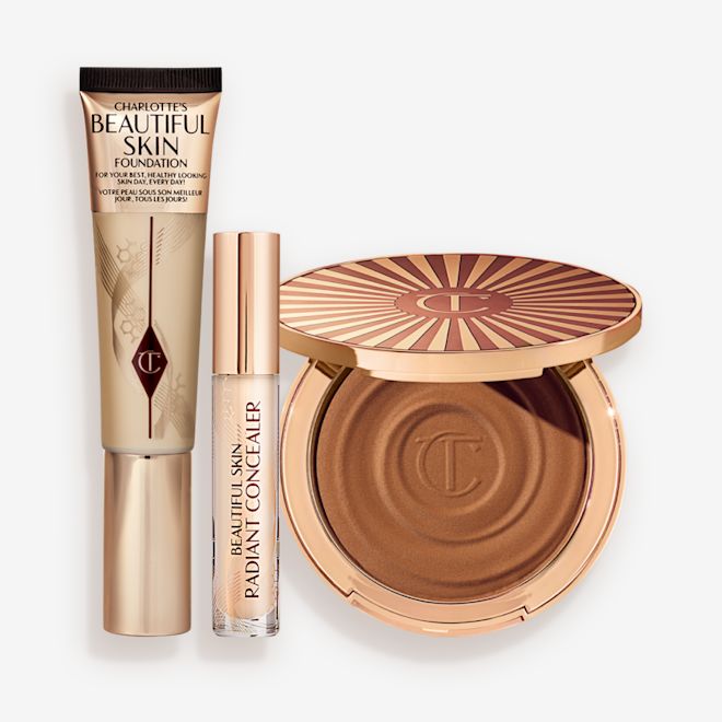Beautiful Skin 3-Step Routine Kit displayed Foundation in a sleek gold-coloured tube with a concealer in a glass tube and gold-coloured lid, and dark brown cream bronzer compact in gold-coloured packaging.