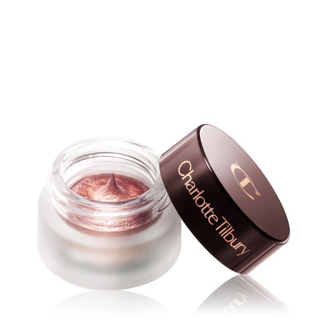 A shimmery, dark rose gold cream eyeshadow in an open glass pot with a dark brown-coloured lid. 