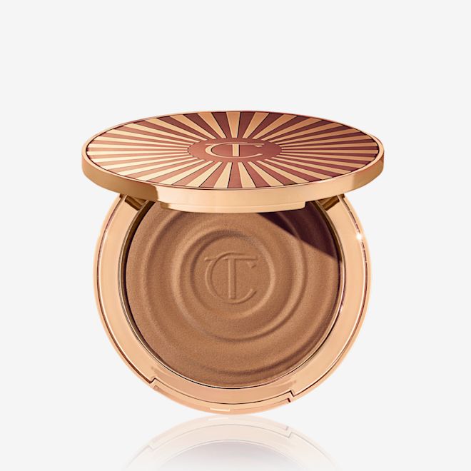 Beautiful Skin Sun-Kissed Glow Bronzer en Deep (Oscuro) abierto Bronceador en crema abierto en un tono marrón arena claro con un envase color dorado.