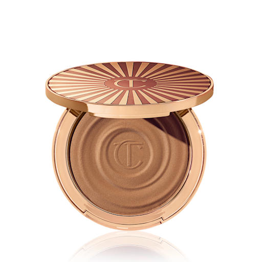 Beautiful Skin Sun-Kissed Glow Bronzer in Deep (molto scuro) aperto Bronzer in crema compatto aperto in una tonalità marrone sabbia chiaro con confezione di colore oro.