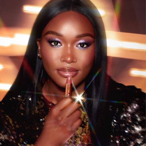 Model holding Matte Revolution Lipstick in Pillow Talk Model holding Matte Revolution Lipstick in Pillow Talk