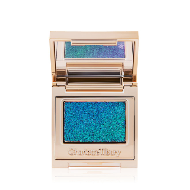 An open, single-pan eyeshadow with a mirrored lid in an iridescent duo-chrome purple and teal shade with very fine shimmer. 