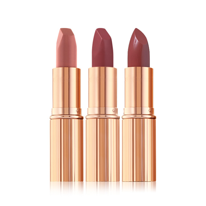 Three open matte lipstick in nude pink, berry-pink, and berry-rose shades in metallic, golden-coloured packaging. 