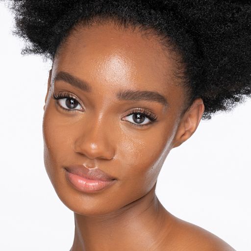 Beautiful Skin Foundation in 13W on deep-tone model Dark-tone brunette model wearing glowy, skin-like foundation with a satin finish with nude lipstick and subtle eye makeup.