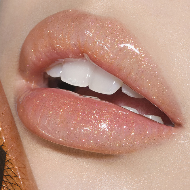 Lips close-up of a fair-tone model wearing sheer gold lip gloss with a high-shine finish.