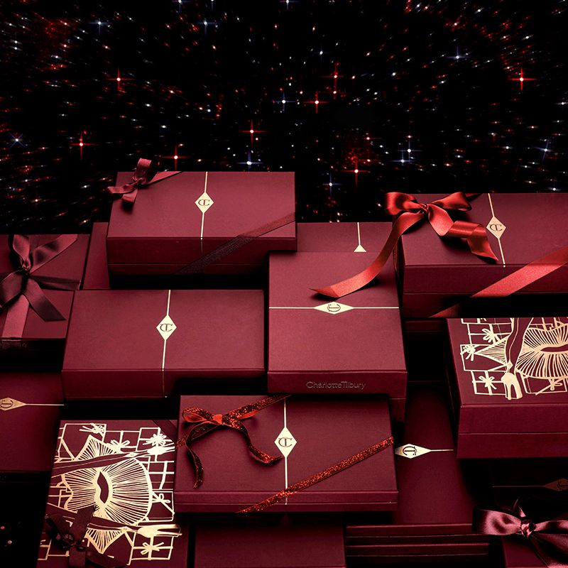 An array of intricately packaged gifts in crimson and golden wrapping with the CT logo printed on them.