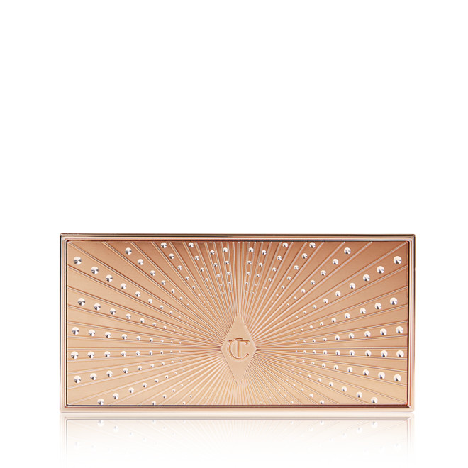 A closed duo contour palette with a light gold-coloured lid with a starburst pattern on top in a darker shade of gold lined with rhinestones. 