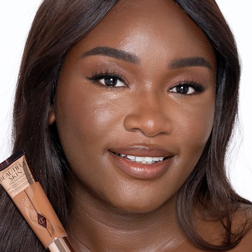 Beautiful Skin Foundation in 14N on a deep-tone model Deep-tone brunette model with brown eyes wearing nude pink lipstick with a skin-like foundation with a flawless, dewy finish.