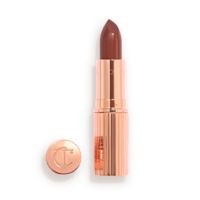 K.I.S.S.I.N.G Pillow Talk Intense Lipstick lid removed Opened, berry-pink lipstick in a metallic, golden case with its lid that's embossed with CT placed next to it.