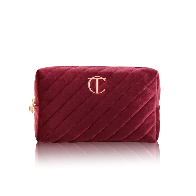 Red velvet makeup bag with the CT logo on the top in golden colour.