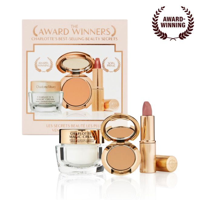 Pearly-white face cream in a glass jar with a gold-coloured lid, pressed powder compact in a tan shade, and a dusky pink lipstick in a sleek gold-coloured tube.