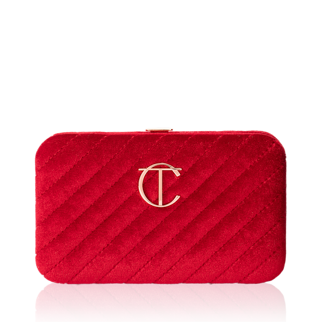 Charlottes Magic Mini Brush Set closed A closed, bright-red-coloured velvet brush clutch with the iconic CT logo on the front in gold.