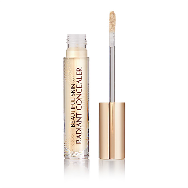 Light beige radiant concealer in a glass tube with its gold-coloured lid with a doe-foot end next to it, and text on the tube that reads, 'Beautiful Skin Concealer'