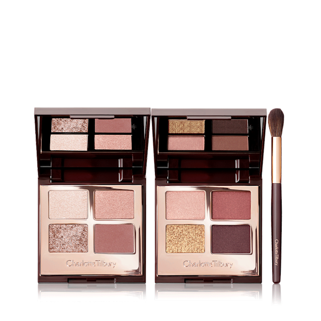 Eye Enhancing Palette Kit open Two, quad eyeshadow palettes with mirrored-lids with eyeshadows in shades of pink, peach, gold, red, and brown along with an eyeshadow blending brush with soft brown-coloured bristles and a gold and brown-coloured handle.