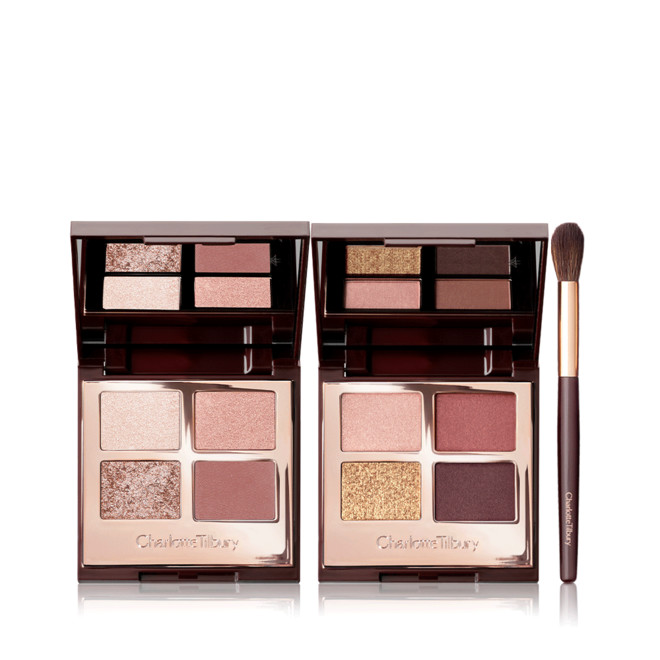 Two, quad eyeshadow palettes with mirrored-lids with eyeshadows in shades of pink, peach, gold, red, and brown along with an eyeshadow blending brush with soft brown-coloured bristles and a gold and brown-coloured handle.