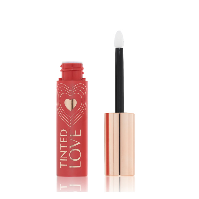 An open lip and cheek tint with a gold-coloured lid in a warm peachy-brown-coloured tube.