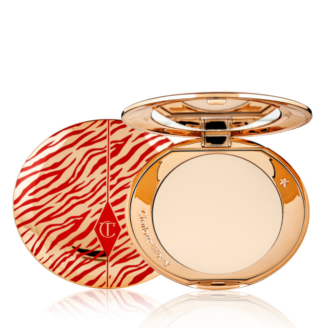 An open, pressed powder compact for fair skin tones with a mirrored lid, in gold-coloured packaging with red-coloured tiger stripes on the lid.