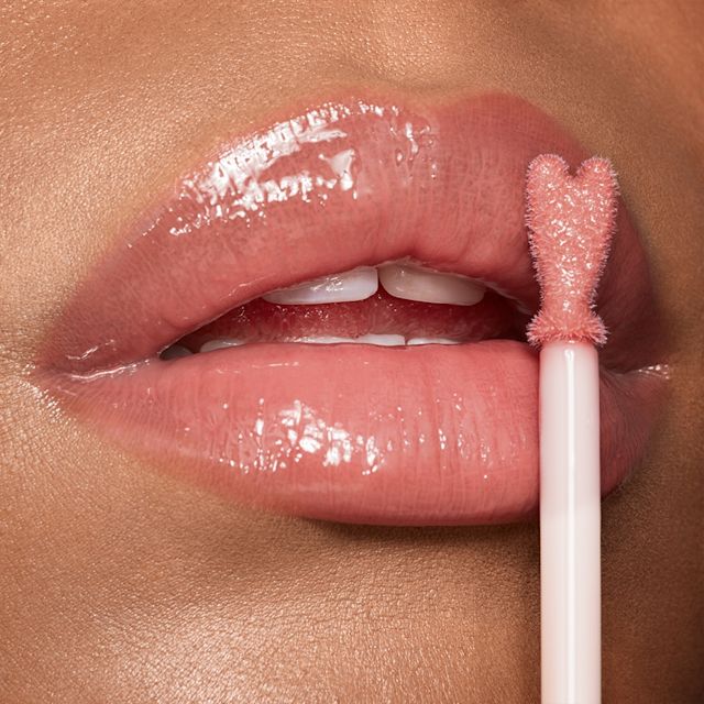 Collagen Lip Bath close up Model applying Collagen Lip Bath plump-effect lip gloss in Pillow Talk