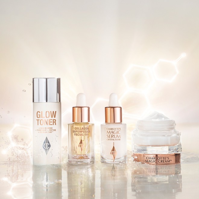 Banner with a travel-size bottle of toner, facial oil in a glass bottle with a dropper lid, serum in a glass bottle with a dropper lid, and pearly-white face cream in a glass jar with a gold-coloured lid.