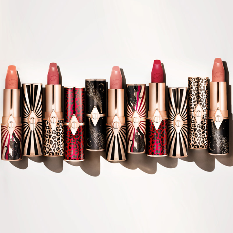 A collection of satin-finish lipsticks in shades of peach, pink, nude pink, and red with funky, printed cases. 