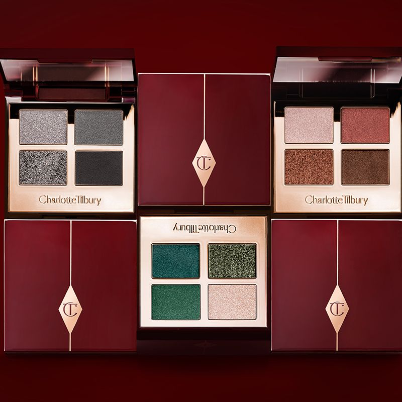 Three open, quad eyeshadow palettes in shades of grey, green, and brown. 