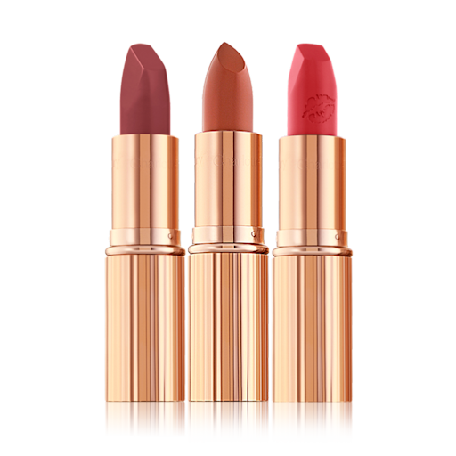 Day to Date Lip kit open Three open lipsticks in shades of plum, nude terracotta, and fire engine red, in gold-coloured tubes.