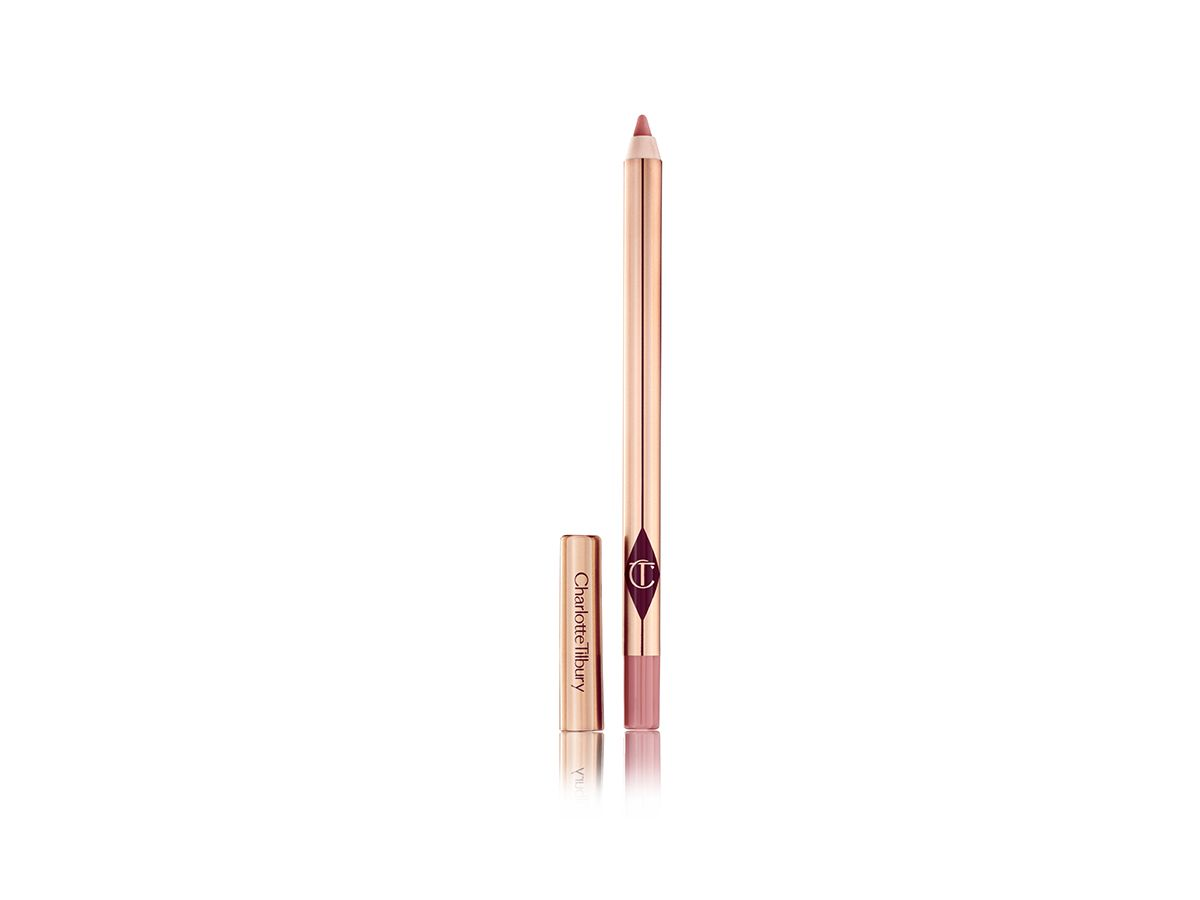 Lip Cheat in Pillow Talk open An open, nude-pink lip liner in rose gold packaging with its lid next to it.