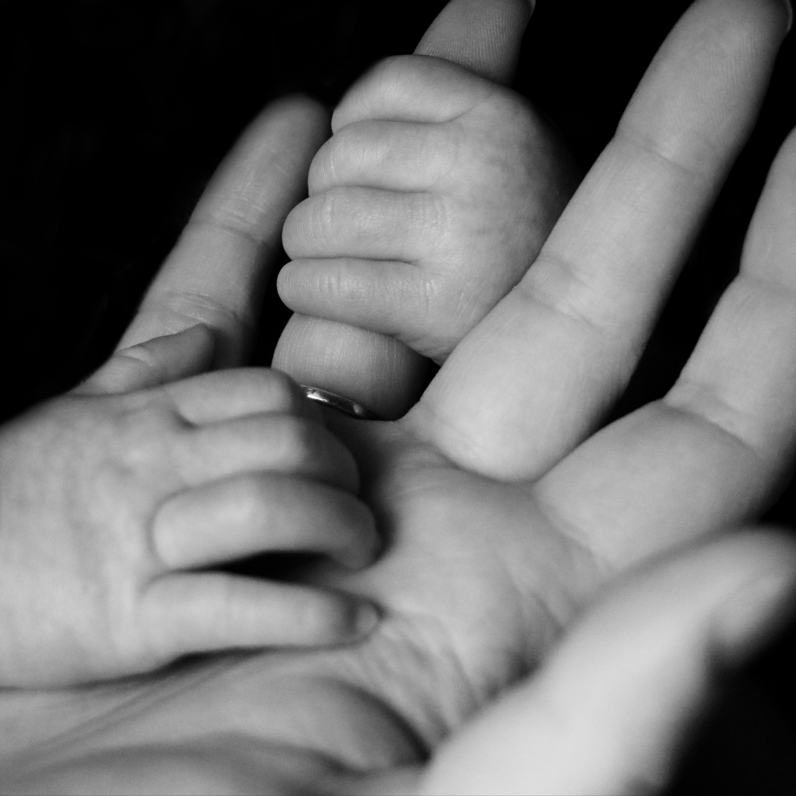 Baby hand holding fingers of adult hand. Photo by Liv Bruce on Unsplash