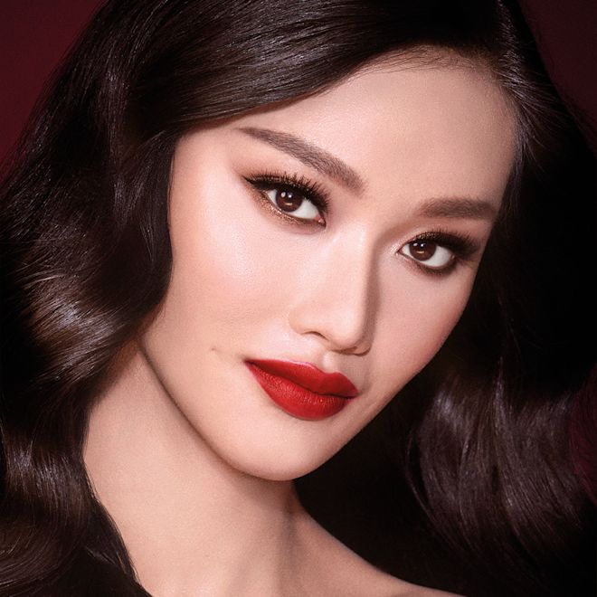 The Bombshell look on fair-tone model with brown eyes A fair-tone model with brown eyes wearing shimmery bronze eye makeup with muted pink blush and glossy scarlet-red lips