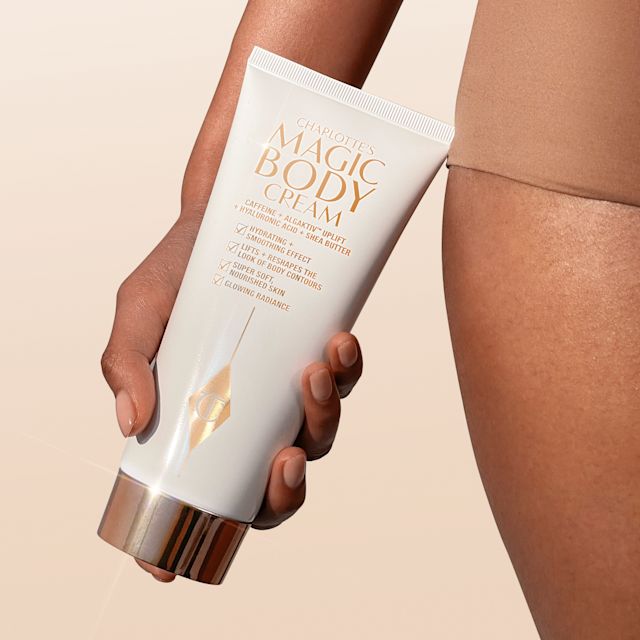 Magic Body Cream model shot Model holding Charlotte's Magic Body Cream for smoother, firmer-looking skin