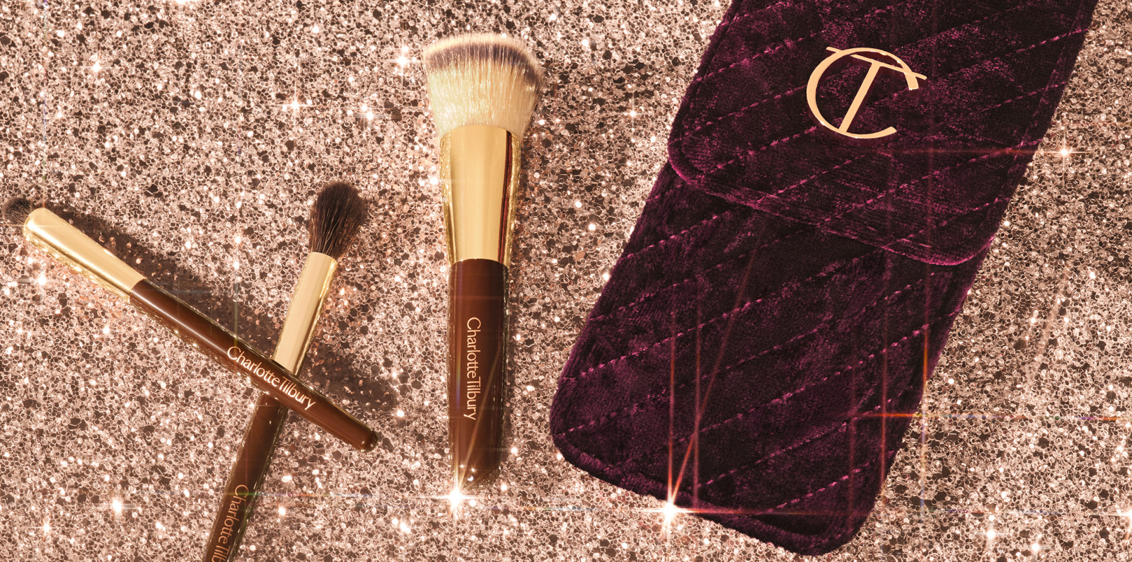 A face blending brush with two eyeshadow brushes, one for smudging and the other for blending eyeshadow, in gold and dark brown colour scheme along with a makeup brush bag in a dark crimson and gold colour scheme.