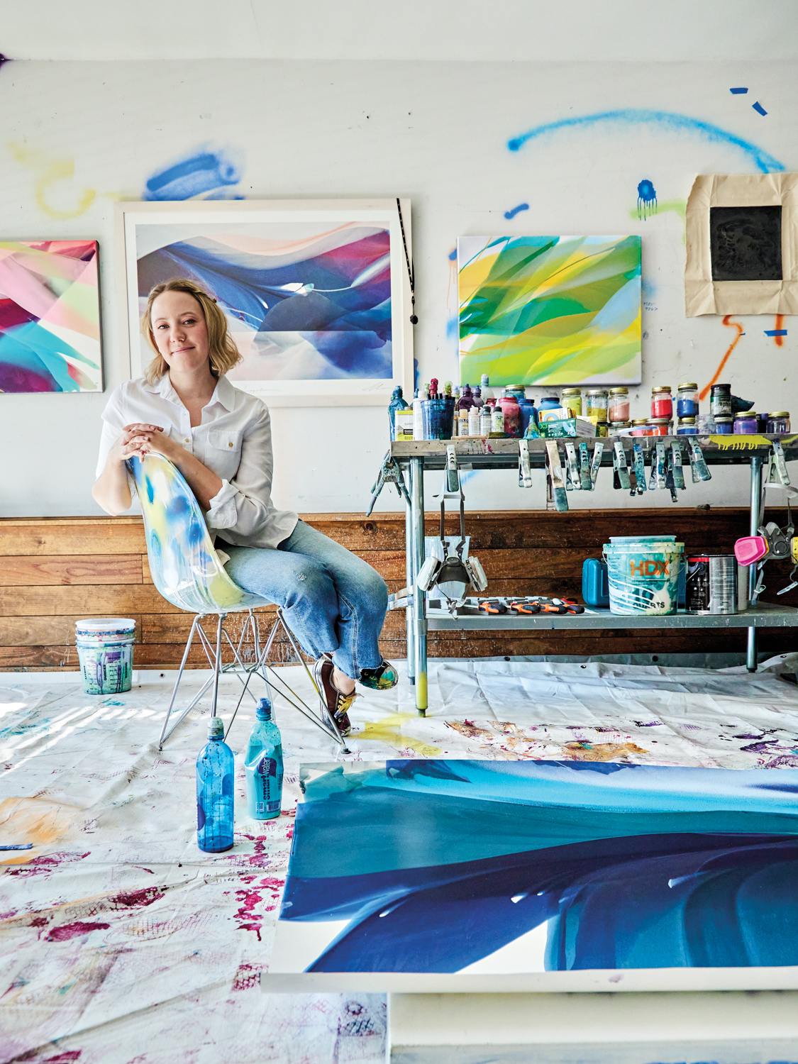 Smiling woman sitting in chair within artist studio