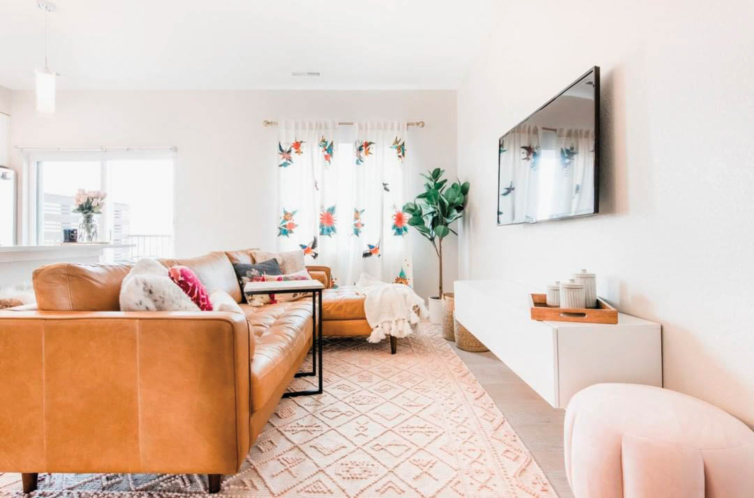 brown leather couch on pink rug