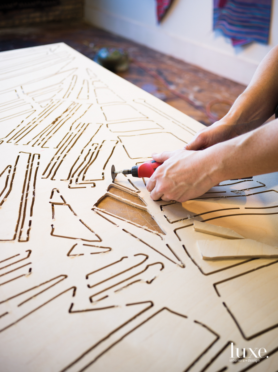 Dan Gunn hand cutting plywood in his studio.