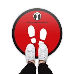 Round floor sticker with a red background and the text "Keep a safe distance - Wait here"