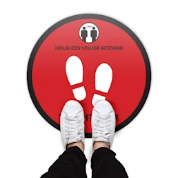 Ronde vloerstickers met een rode achtergrond en de text "Houd een veilige afstand - wacht hier"