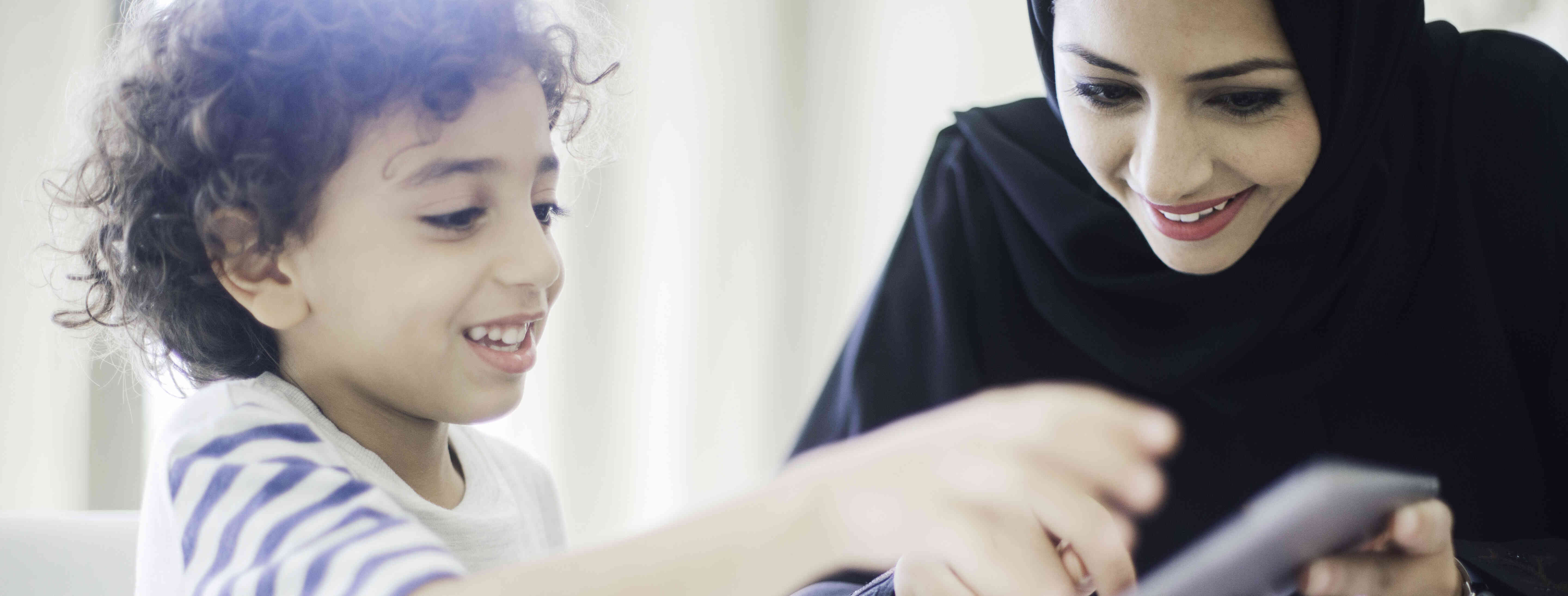 babysitter helping kid with hybrid learning at home