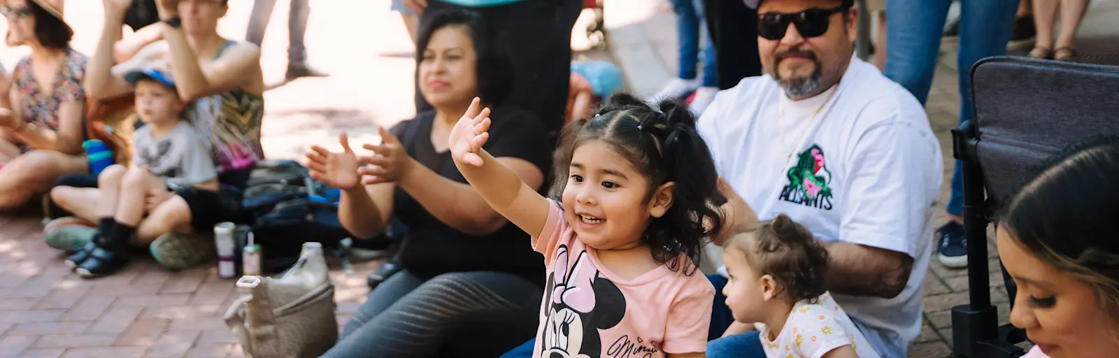 Waving child with family at the Flint Hills Family Festival. Photo by Laura Alpizar.